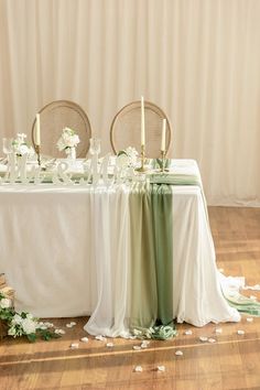 the table is set up with white flowers and greenery for an elegant wedding reception