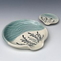 two ceramic dishes with designs on them sitting next to each other