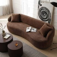 a brown couch sitting on top of a hard wood floor next to a coffee table