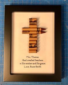 a cross made out of pencils in a frame