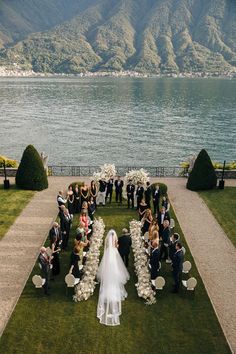 a bride and groom walking down the aisle to their wedding ceremony at lake comoni