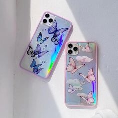 two phone cases sitting next to each other on top of a white surface with butterflies painted on them