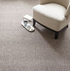 a white chair sitting on top of a carpeted floor next to a pair of flip flops