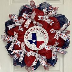 a red, white and blue mesh wreath with the word god bless texas on it