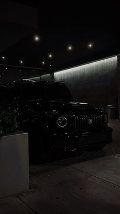 a black jeep parked in front of a building with lights on it's sides