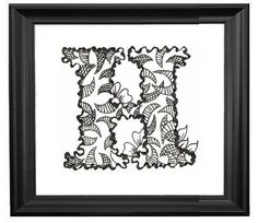 the letter d is made up of flowers and leaves in black framed paper on a white wall