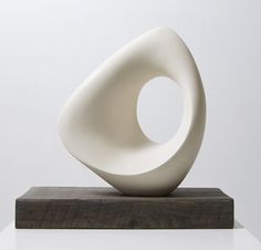 a white sculpture sitting on top of a wooden block