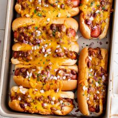 six hot dogs with toppings in a pan