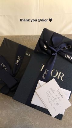 two black books tied together with a blue ribbon and thank you eidor card