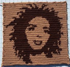 a crocheted square with an image of a woman's face on it