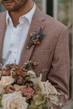 a man in a suit holding a bouquet of flowers