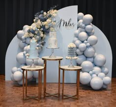 two tables with cake on them in front of a backdrop