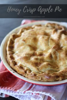 an apple pie sitting on top of a red and white plate with the words honey crisp apple pie