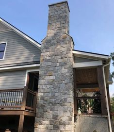 a tall brick chimney in front of a house