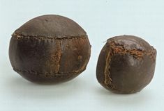 two pieces of chocolate that have been split in half to look like balls with holes on them