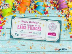 a birthday party ticket surrounded by confetti and streamers on a blue wooden table