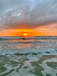 the sun is setting over the ocean waves