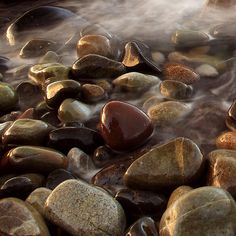 some rocks and water with steam coming from them