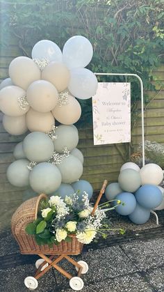 balloons and flowers are on display in front of a welcome sign