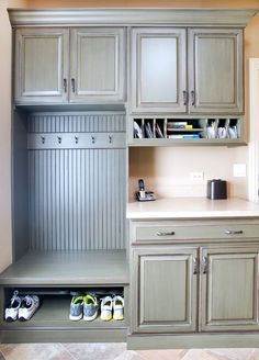 a kitchen with wooden cabinets and shoes on the floor