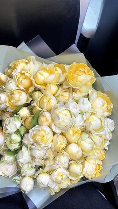 a bouquet of flowers sitting on top of a table next to a black and white chair