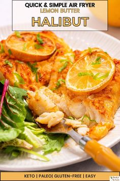 a white plate topped with chicken and lemon slices on top of lettuce next to a fork