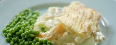 a white plate topped with mashed potatoes and peas