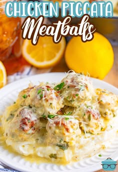 chicken piccata meatballs on top of mashed potatoes with lemons in the background