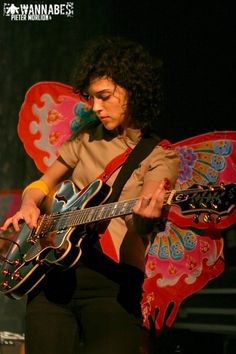 a woman playing an electric guitar on stage