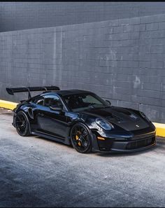 a black sports car parked in front of a building