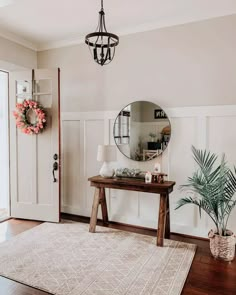 a living room with a rug, mirror and potted plant