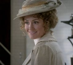 a woman with curly hair wearing a hat