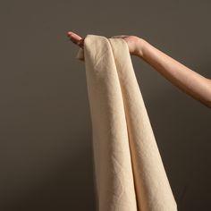 a person's hand holding an unbuttoned piece of cloth