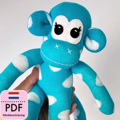 a hand holding a blue monkey stuffed animal