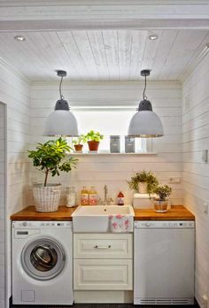 a washer and dryer in a small room with wood counter tops on the floor