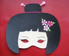 a woman's mask with flowers on it and a black hairdow in the background