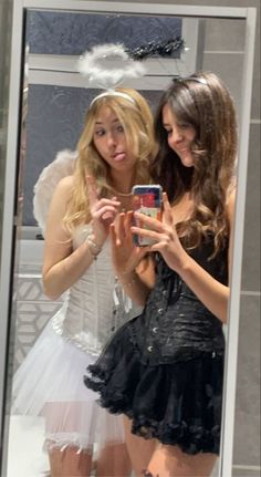 two beautiful young women standing in front of a mirror