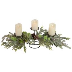 three white candles are sitting on a metal stand with evergreen leaves and pineconis