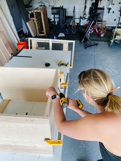 a woman is working on some drawers in a room full of workbench tools