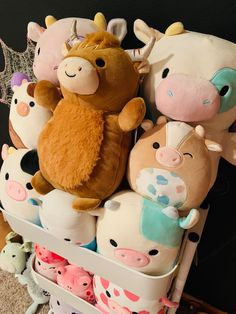 several stuffed animals sitting on top of each other in a toy storage bin with toys