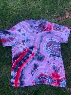 a tie dyed shirt laying on the grass