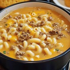 a bowl of pasta soup with meat and cheese on the top is ready to be eaten