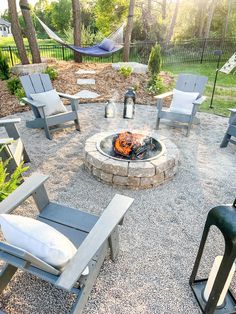 a fire pit surrounded by lawn chairs and hammocks