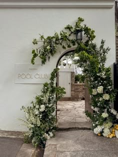 the entrance to pool club is decorated with greenery and white hydrangea flowers