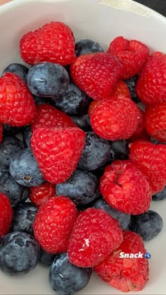 blueberries and raspberries in a white bowl