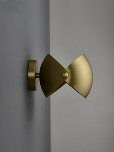 a close up of a door handle on a white wall with a light in the background