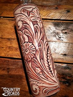 an intricately decorated flask is sitting on a wooden table with wood planks