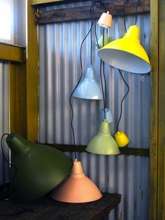 several different colored lamps are hanging from the ceiling