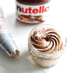 nutella in a glass jar next to an empty container with peanut butter on it