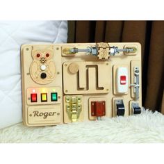 a wooden peg board with sewing tools and buttons in it on a white furnishing